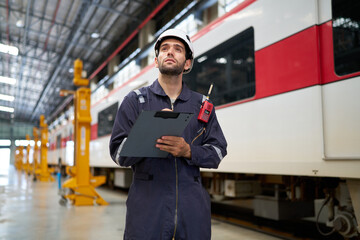 Technician or worker writing and checking on clipboard at train construction site