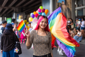 Young beautiful asian lesbian with pride movement LGBT holding rainbow flag raise up for freedom....