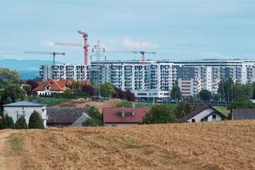 construction site with cranes, apartments and suburbs