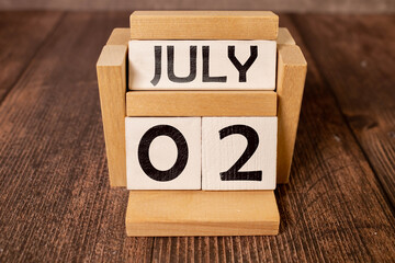 Close up of a wooden perpetual calendar showing the 2nd of July.