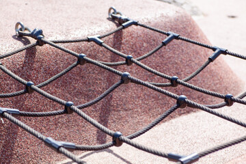 Close-up view of a playground climbing net, showcasing the durable materials and secure fastenings.