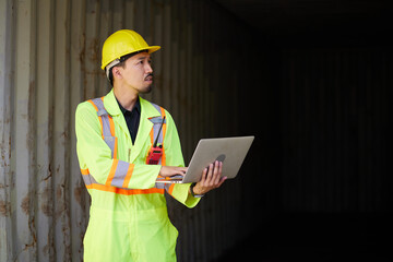 worker or engineer working on laptop computer in containers warehouse storage