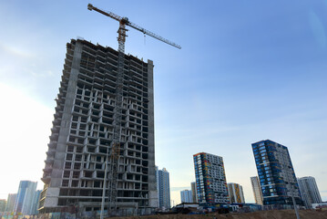 Construction site with buildings under construction. Tower cranes in action. Crane during formworks of house. Multi Storey Residential Buildings construction. Tower crane on Housing renovation.