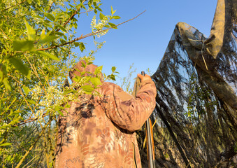 Hunter while hunting a wild bird. Hunters with gun and rifle on hunting. Hunters during duck hunting. The hunter shoots the birds of goose in the sky.