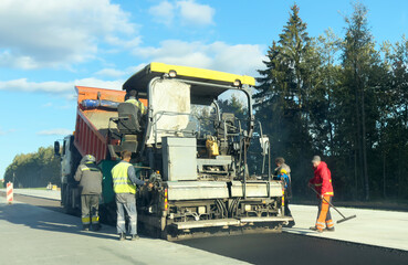 Obraz premium Highway construction. Asphalt paver machine on road work. Road Machinery at road construction. Concrete Paving works, road concreting. Asphalt pavement, concrete pavement. Highway concrete pavement