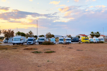 Campervan in camp parking near beach at coastline. Family rv camper van vehicle at seaside. Rving motorhome lifestyle travel to sea. Travel on Campervan along Spain coast. Caravaning Parking. Camping