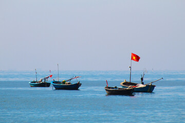 Photograph of traditional Asian fishing boats floating in the sea near Da Nang, Vietnam. Captures the serene coastal life and maritime culture