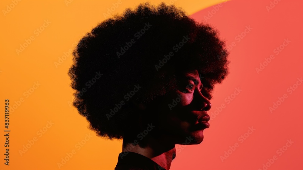 Wall mural a side profile of a black man with an afro against a bright red and orange background