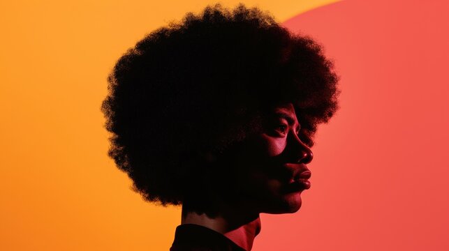 A side profile of a Black man with an afro against a bright red and orange background
