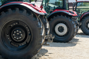 Row of red agricultural tractors for sale.