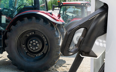 Fototapeta premium Electric vehicles charging station on a background of agricultural tractor. Concept