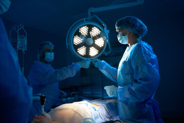 Nurse assisting to doctor surgeon during surgical operation in operating room