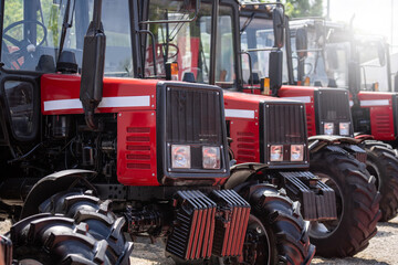 Row of red agricultural tractors for sale.