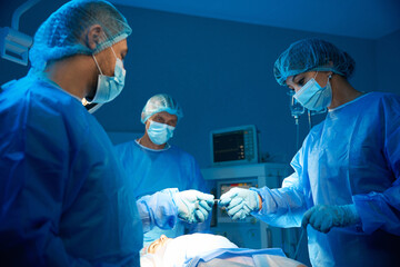 Team of surgeons performing abdominal surgery to remove tumor