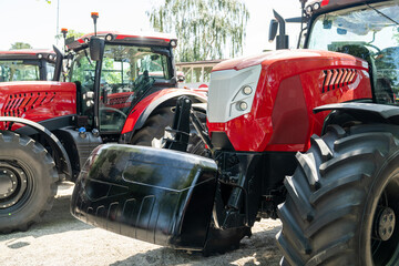 Row of red agricultural tractors for sale.