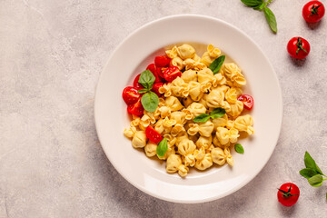 Sacсhettini pasta in a plate with tomato sauce.