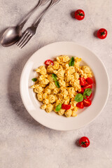 Sacсhettini pasta in a plate with tomato sauce.