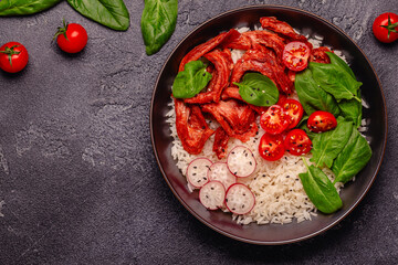 Bowl with vegan fried soy meat and vegetables served with boiled rice.