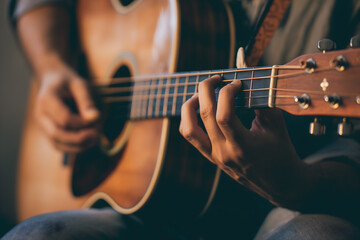 Fototapeta premium Close-Up of Guitarist Fingers Strumming Acoustic Guitar