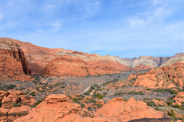 Aerial View of the stunning Snow Canyon State Park landscape with park trail winding through. Navajo red sandstone cliffs, petrified sand dunes and rugged mountains - St George, Utah, USA