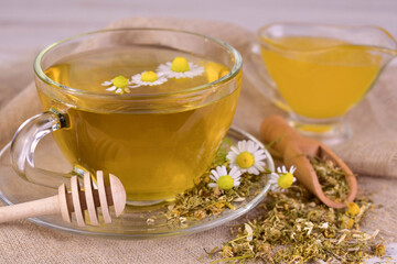 Herbal chamomile tea with honey, and medicinal chamomile flowers. Close-up.
