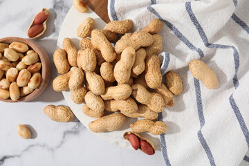 Fresh peanuts on white marble table, flat lay