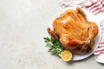 Tasty roasted chicken with parsley and lemon on light grey table, top view. Space for text