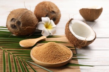 Coconut sugar, palm leaves, fruits and bamboo mat on wooden rustic table, closeup