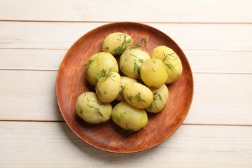 Tasty young boiled potatoes with dill on wooden table, top view