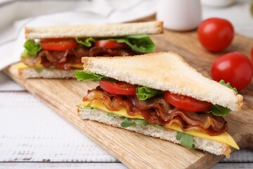Delicious sandwiches with fried bacon on wooden rustic table, closeup