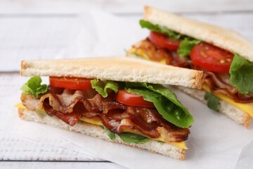 Delicious sandwiches with fried bacon on wooden rustic table, closeup