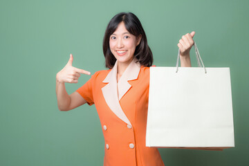 Smiling woman pointing with shopping bag