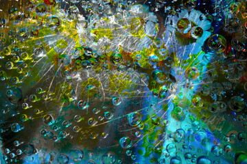 Translucent raindrops are illuminated by a flash of blue-green light and are located against a black background. Space abstraction. 3D render.
