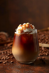 Iced caramel latte topped with whipped cream and caramel sauce.