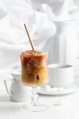 Iced coffee with cream and cup of black coffee.
