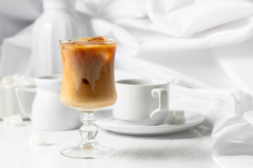 Iced coffee with cream and cup of black coffee.