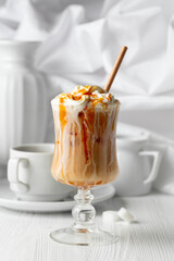 Iced caramel latte topped with whipped cream and caramel sauce.