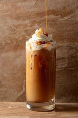 Iced caramel latte topped with whipped cream and caramel sauce.