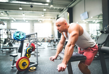 Strong man exercising in gym. Routine workout for physical and mental health.