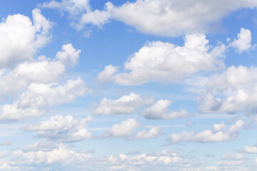 Beautiful light cloudy blue sky with many white fluffy cumulus clouds, background texture, heaven