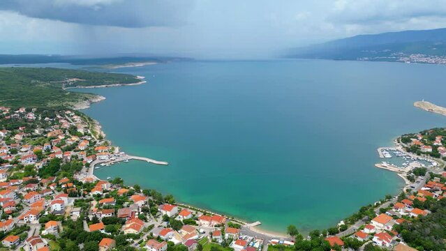 &Scaron;ilo is a charming small village on the island of Krk, Croatia, perfect for a summer vacation. Captured by drone, &Scaron;ilo showcases its beautiful cape and picturesque marina