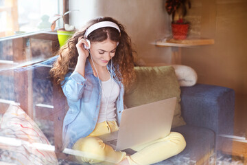 Beautiful woman with curly hair wearing headphones, listening music, positive affirmations.