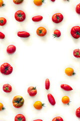 Red and yellow tomatoes, fresh farm tomatoes of various colors and cultivar on a white background with space for text. Top view, flat lay