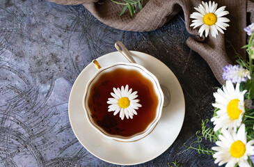 Herbal tea, chamomile flowers and honey on rattan matting Close-up