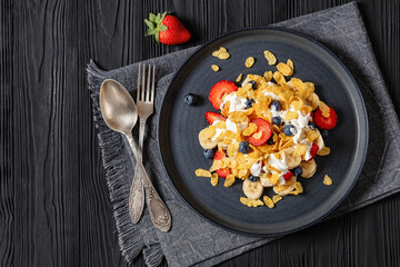 fresh berries, banana with corn flakes and yogurt
