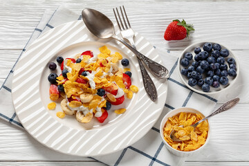 fresh berries, banana with corn flakes and yogurt