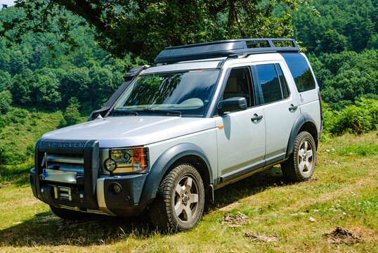 land rover discovery 3, LR3, gray, ready for expeditions and overland and off-road trips, by the road seen from the side on top of the hireva. In the nose of the car you can see an electric rescue win