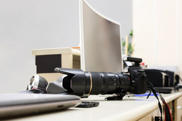 Photographer's office. Photographer's work desk has camera, computers, computer screen and printers