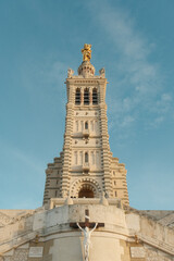 Fototapeta premium Golden Statue on the top of an intricately designed cathedral, with a Jesus statue at the base