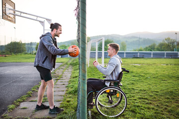 Disabled young man feeling excluded, want to play basketball with his friends, but because of...